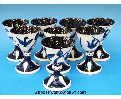 A set of eight Wilfred Gibson blue and white ceramic goblets with bird decoration