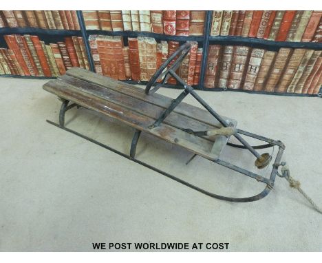 A vintage toboggan /sled with steering and brake
