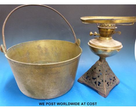 A heavy brass cooking pan and a brass oil lamp with pieced decorated stand 