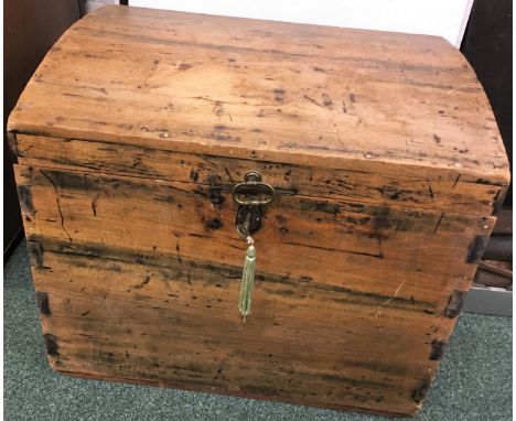 A small dome topped pine trunk with brass lock and handle to lid and iron carrying handles, height 49.5cm, width 60cm, depth 