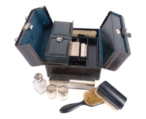 A travel case, circa 1920s, fitted with ebony brushes, a razor, and glass jars with plated tops, L25cm