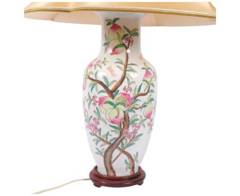 A Chinese porcelain table lamp with floral decoration, on wooden plinth with cream shade, H82cm overall