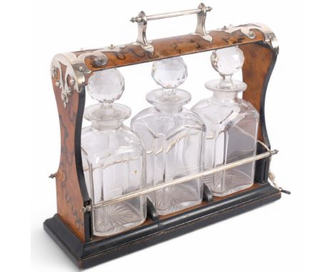 A Victorian Gothic silver plate mounted ebonised burr-walnut 3-bottle tantalus, with 3 fitted square glass decanters, all uns