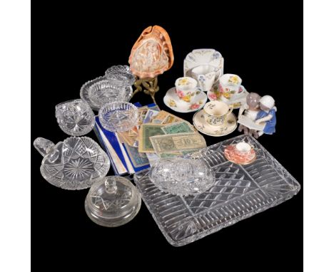 A carved nautilus shell lamp, miniature cups and saucers, banknotes, and glassware