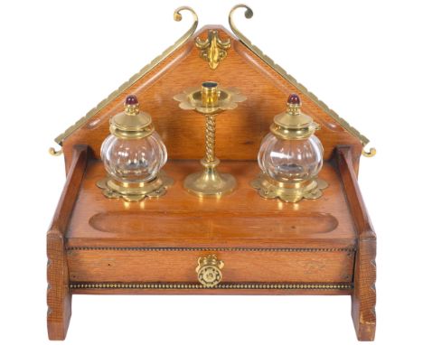 A Victorian Gothic brass-mounted oak desk inkstand, with original removeable glass fitted inkwells, sealing wax candle holder