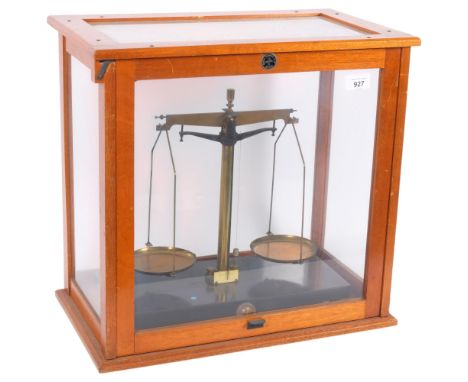 A pair of laboratory balance scales in glazed case