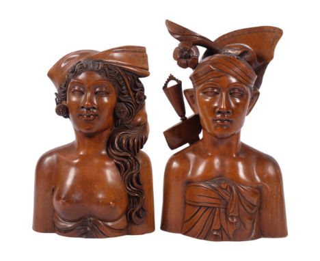 A pair of carved hardwood sculptures, young man wearing a hat, H34cm, and bust of a young woman, both impressed Klunghung, Ba