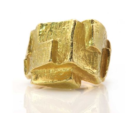 An 18ct gold cubist ring, by Kutchinsky, c.1960,with staggered geometric sections to a peaked head, with a molten effect text