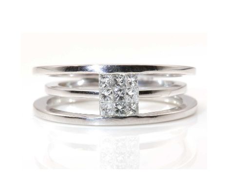 An 18ct white gold diamond set contemporary band ring,with a pair of deep guards, supporting a rectangular plaque of nine inv