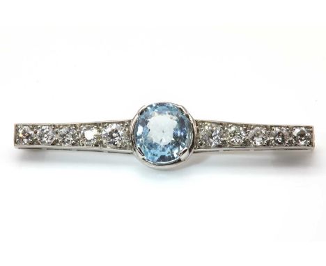 A French Art Deco aquamarine and diamond graduated bar brooch, with an oval Lisbon cut aquamarine, four claw set to the centr