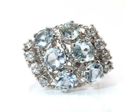 An aquamarine and diamond bombé style cluster ring, c.1950, with two diagonal rows of circular mixed cut aquamarines, all fou