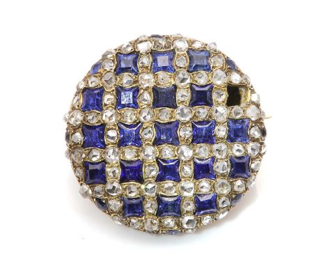 A Victorian sapphire and diamond circular cluster brooch,of light bombé form. Rows of calibré cut sapphires with re-entrant s