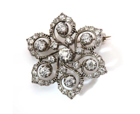 A Victorian diamond set flower head brooch/pendant, c.1890,with an old European cut diamond, in a cut down collet at the cent