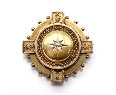 A late Victorian Etruscan style diamond set target brooch, c.1880,with a cushion cut diamond, star set to a raised central bo