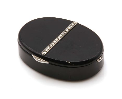 A French Art Deco set onyx, gold and platinum compact or pill box,of oval flat section form. The hinged oval onyx box with a 