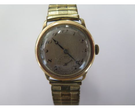 A 9ct yellow gold manual wind wristwatch on a plated sprung strap - 28mm case - total weight approx 49 grams - cracks to glas