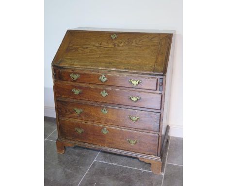 A Georgian elm four drawer bureau with a fitted interior on shaped bracket feet - Height 107cm x 94cm x 55cm - good colour an