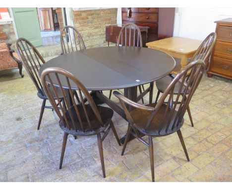 An Ercol drop leaf dining table - Height 72cm x 128cm x 140cm extended with six stick back chairs including two carvers 