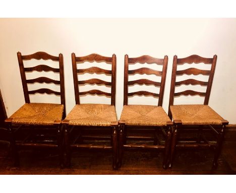 A set of eight late 18th Century elm and fruitwood rush seated chairs, ladder back, raised on straight cabriole legs padded f