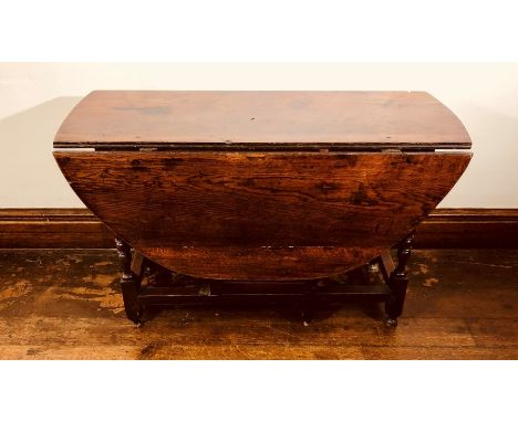 A George III oak gate leg table, circa 1800, oval drop leaf top, raised on&nbsp;baluster turned supports united with square s