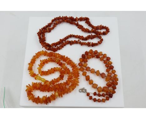 Three rough-cut Baltic amber beaded necklaces. Darkest L: 66 cm, rough cut L: 56 cm, cut stone L: 56 cm. UK P&amp;P Group 1 (