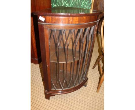 A REPRODUCTION MAHOGANY BOW FRONT CORNER UNIT with fancy bar glazed single door, supported on plain bracket feet 