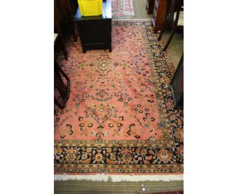 A LARGE PINK GROUND FLORAL DECORATED WOVEN WOOLEN FLOOR CARPET 