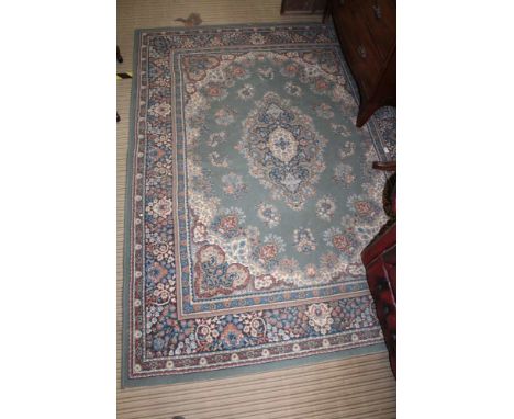 A GREEN GROUND WOVEN WOOLLEN FLOOR CARPET of stylised floral form 