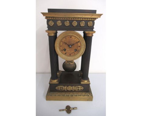 19th Century French Empire portico clock, ebonised and gilt metal case with fluted columns on stepped base, 2 3/4" brass engi