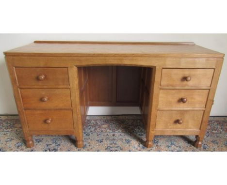 Robert Mouseman Thompson of Kilburn - an oak panelled kneehole desk or dressing table, adzed top above three graduating drawe