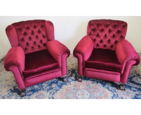 Pair of Edwardian low wing back upholstered armchairs, with deep button back and loose seat cushion on carved cabriole legs w