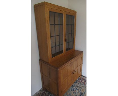 Robert Mouseman Thompson of Kilburn - a panelled oak side cabinet with penny moulded cornice two lead glazed doors above two 