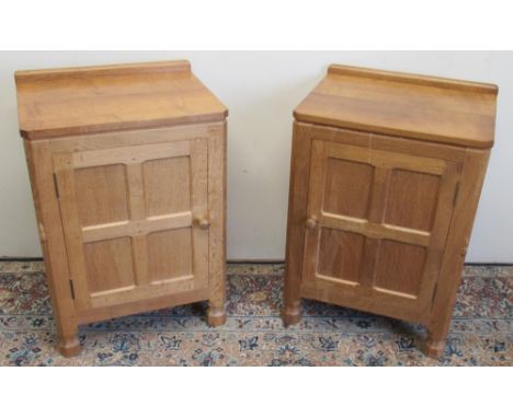 Robert Mouseman Thompson of Kilburn - a pair of panelled oak bedside cabinets sideboard with adzed tops and four panel doors,