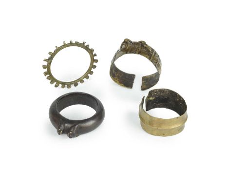 Four Naga banglesNagalandbrass and bronze, including one with two hornbills and panels of double spiral motifs, 8.4cm wide, a