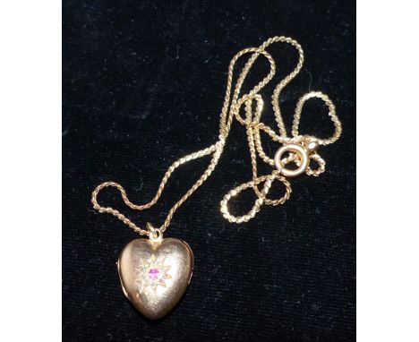 A yellow metal heart shaped locket set with diamond chips and an amethyst, on chain stamped '9CT', locket unmarked, tests as 