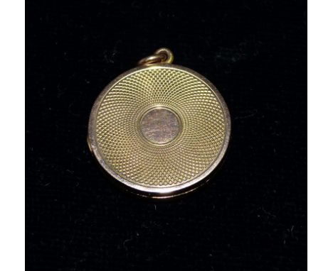 A 9 carat hallmarked gold engine turned circular locket, 5.7 gm