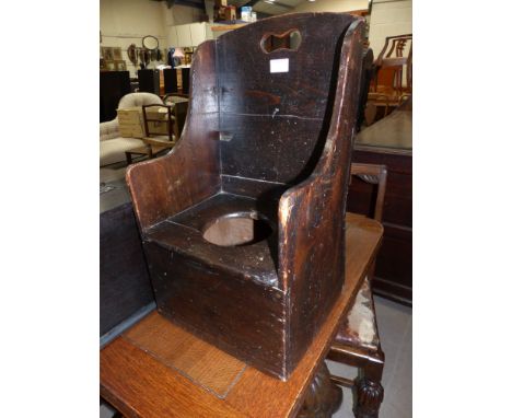 An 18th/19th century child's stained wood commode chair in the form of a lambing chair