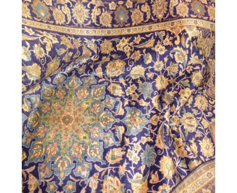 A fine North West Persian Yazd carpet, central floral medallion on a sapphire field within stylised floral border, 340cm x 23