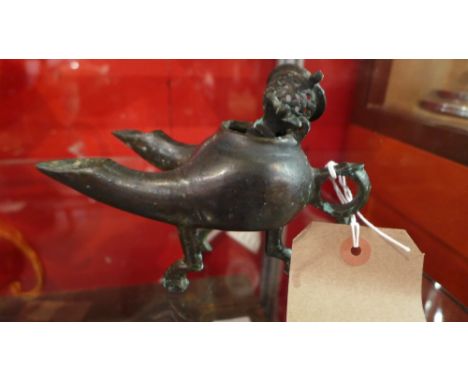 A Khorasan bronze oil lamp squat spherical body on three angled legs extruded at the front into two tubular spouts with horiz