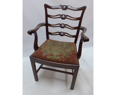 A Georgian style mahogany elbow chair with tapestry drop in seat and raised on reeded legs joined by stretchers. 