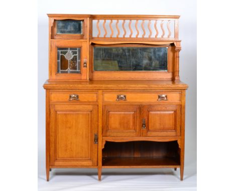 Unknown (English) - An oak sideboard, the upright section with offset single leaded cabinet and two mirror panels, all over t