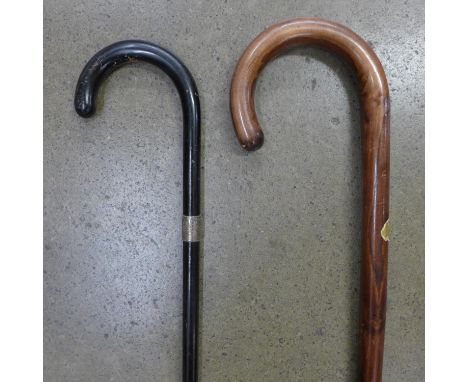 An ebonised walking cane with silver collar and one other walking stick 