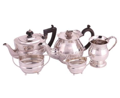 An early 20th-century three-piece silver tea set, the teapot with a wooden handle and finial-topped cover; together with a Vi