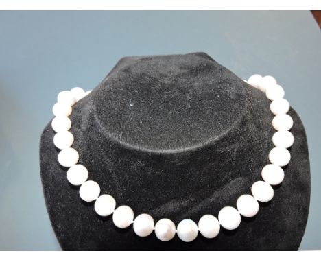 A pearl necklace of uniform sized beads, the clasp pierced and incorporating characters, L.41cm.