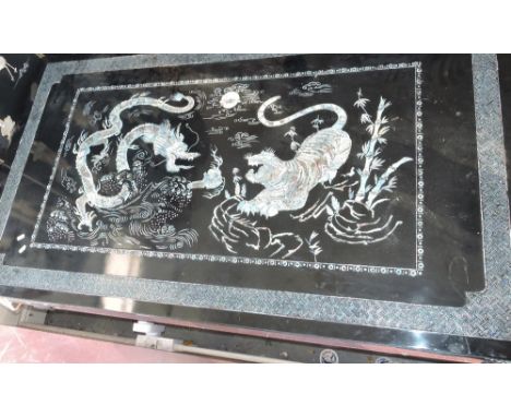 A Chinese black lacquer rectangular low table, the abalone and mother of pearl inlaid top decorated with tiger and dragon mot