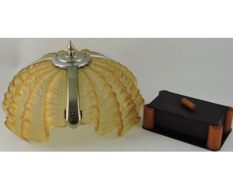 An Art Deco bakelite cigarette box, rectangular with columnar corners, W. 19cm, together with a 1930's moulded amber glass ce