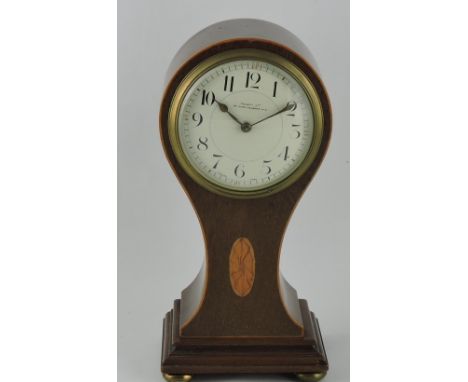 An Edwardian mahogany mantel timepiece, the balloon shaped case fitted with a white enamel dial set out with Arabic numerals,