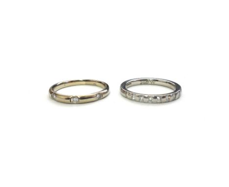 A white gold and diamond three stone band ring, mounted with a row of circular cut diamonds, ring size O and a platinum and d