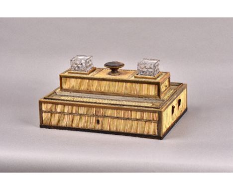 A 19th century Anglo-Indian porcupine quill and horn desk stand, with pair of inkwell recesses and concave pen trays, above a