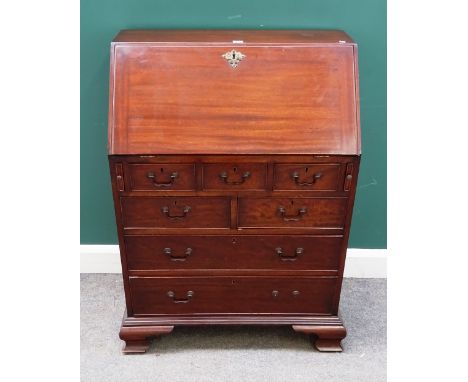 A small George III style mahogany bureau, the fitted interior over three short, two short and two long drawers, on ogee brack
